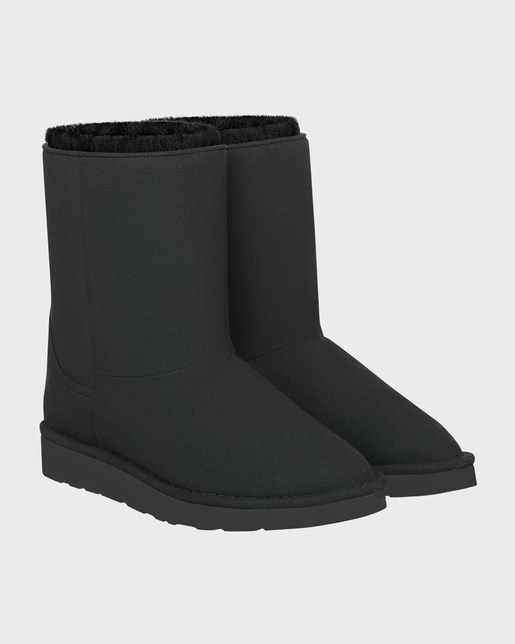 Pair of vegan black boots on a light gray background