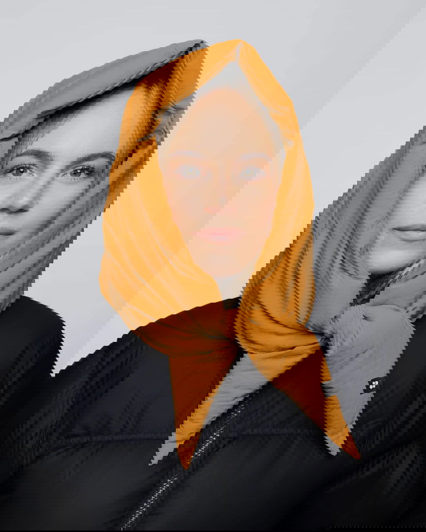 Amber yellow vegan hood made from recycled materials, styled over black puffer jacket. - The New Orchard - Amber Yellow
