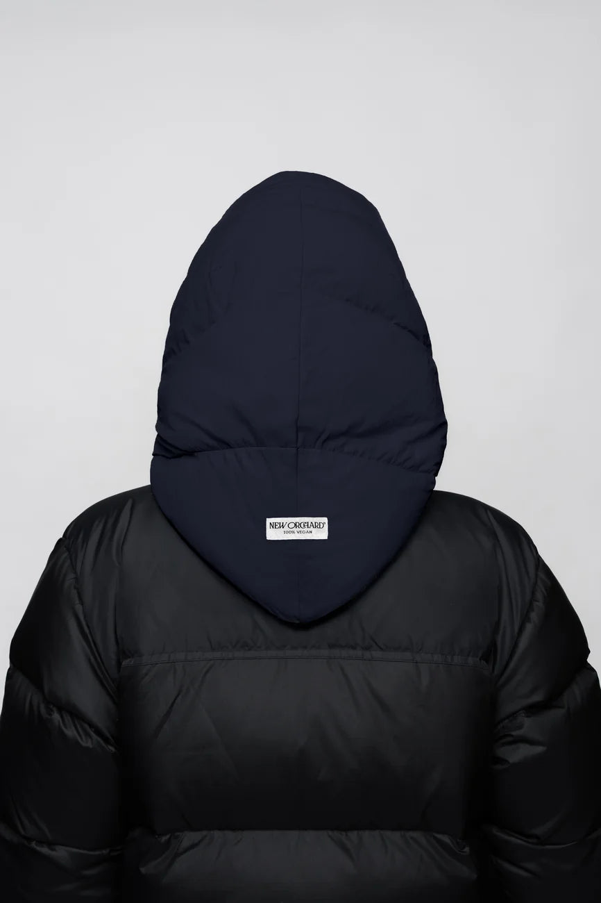 Winter Vegan Capuche Navy 6 Navy blue vegan winter capuche made from recycled materials on black puffer jacket back view. - The New Orchard - Navy Blue