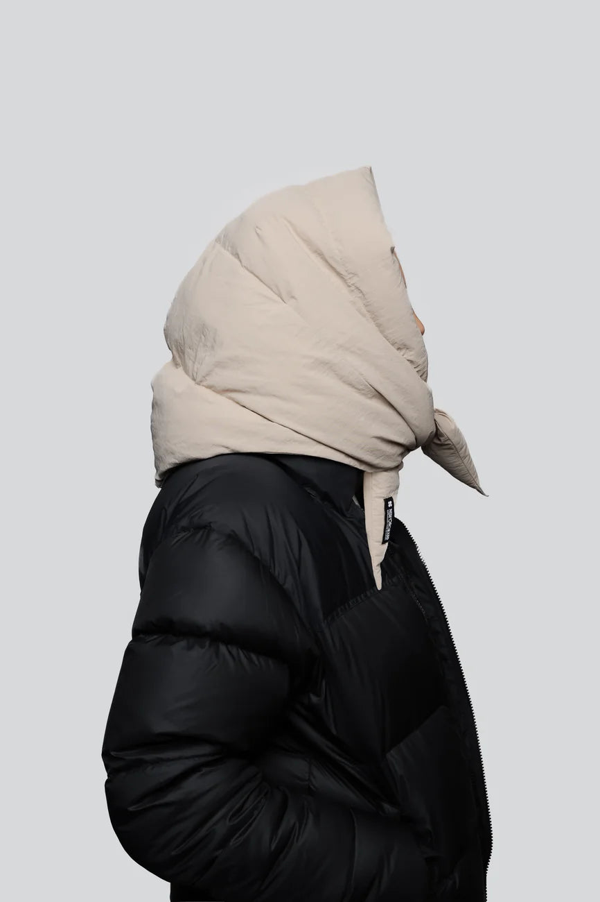 Winter Vegan Capuche Beige 3 Light beige vegan puffer hood made from recycled materials, styled over black jacket. - The New Orchard CH