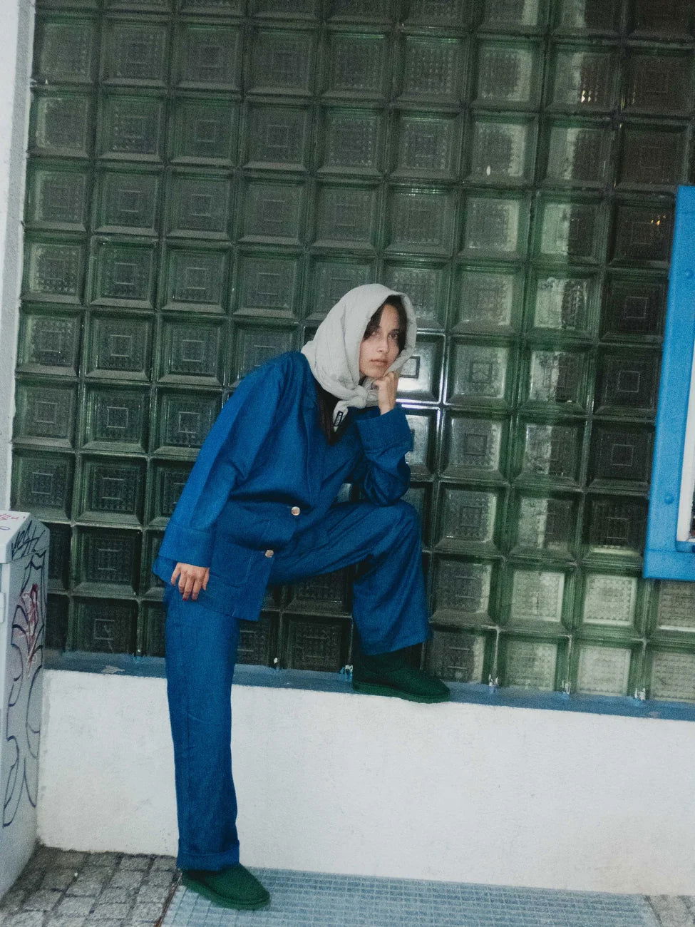 Winter Vegan Capuche Beige 4 Light beige vegan hooded scarf made from recycled materials styled with blue outfit against green glass tile wall. - The New Orchard CH