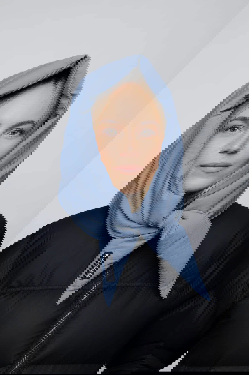 Winter Vegan Capuche Blue 1 Sky blue vegan winter capuche made from recycled materials worn with black puffer jacket. - The New Orchard CH