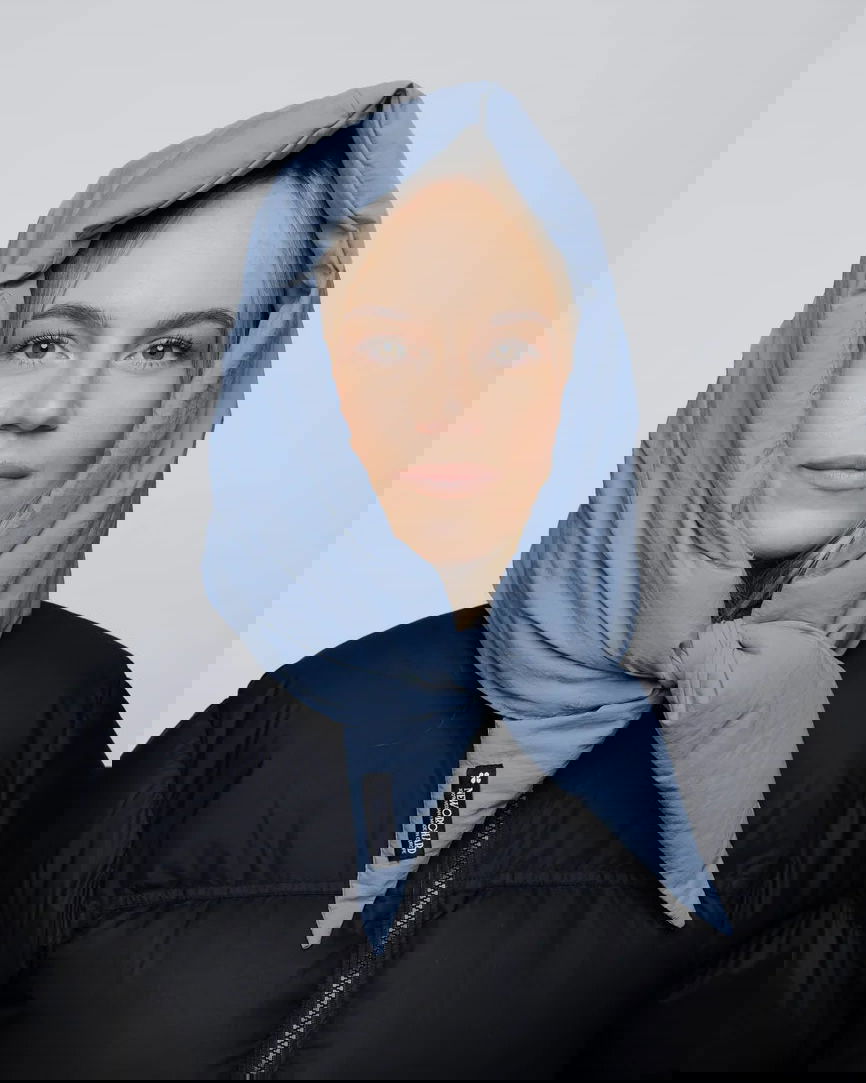 Sky blue vegan winter capuche made from recycled materials worn with black puffer jacket. - The New Orchard CH