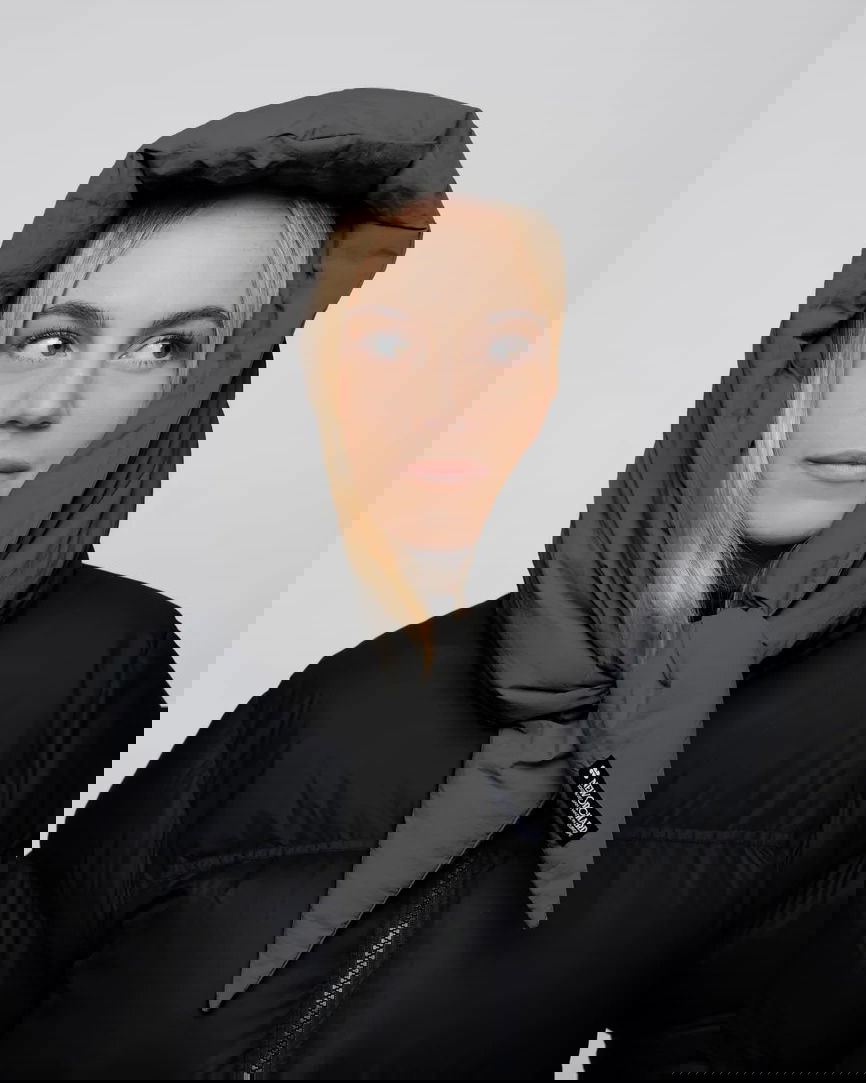 Light grey vegan capuche hood made from recycled materials, styled with black puffer jacket. - The New Orchard CH